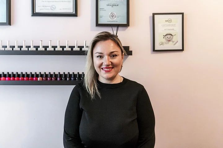 Lachende medewerker van KiSO beauty voor de planken met nagellak