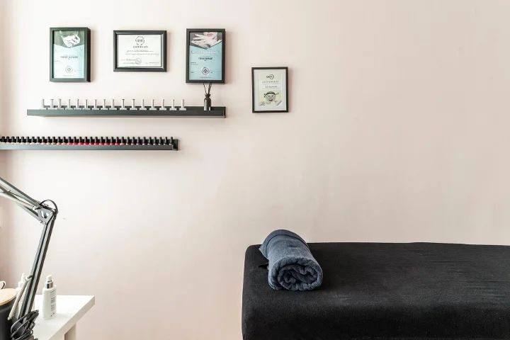 Nageltafel met lampen en de behandelbank met opgerolde handdoek